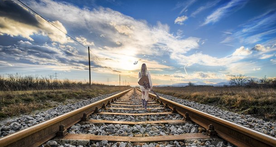 Foto de uma mulher andando na linha do trem