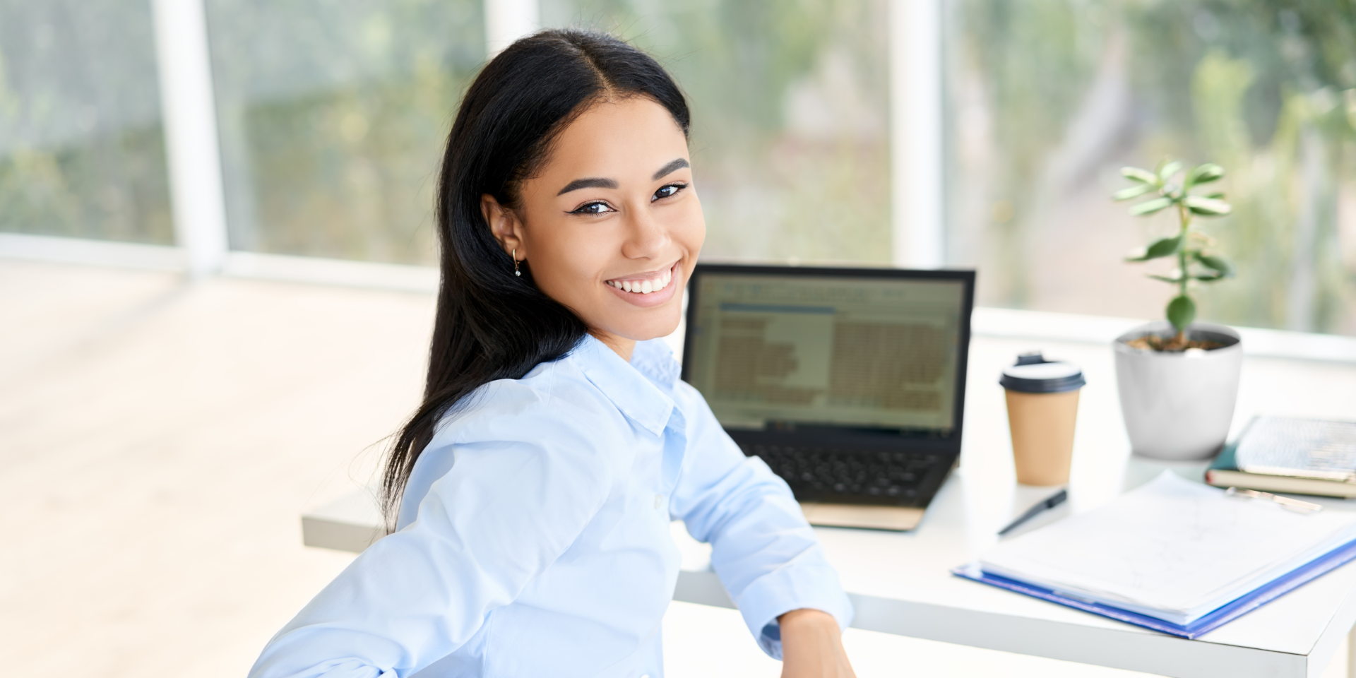 mulher no trabalho sentada próxima a um computador